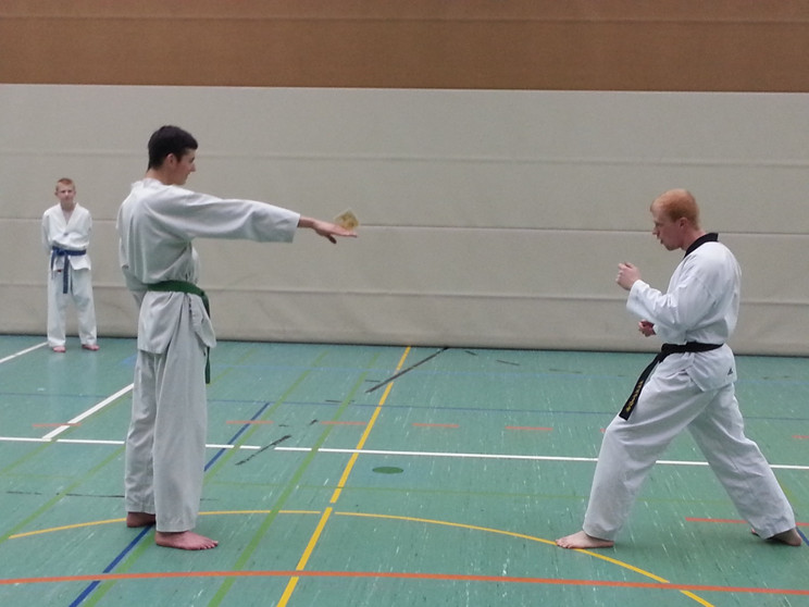 Bierdeckel zwischen die Finger klemmen, Zielen...